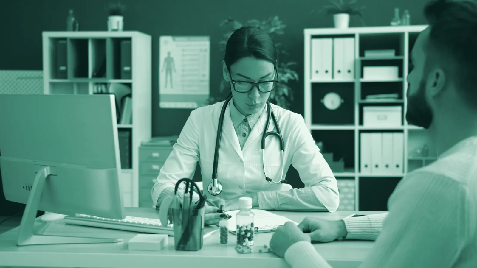Illustrative photo: a doctor listens to a patient across her consulting-room desk.