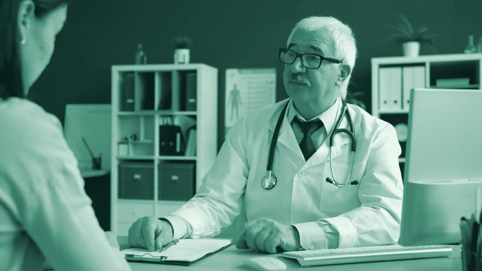 Illustrative photo: a doctor at his desk talking with a patient.