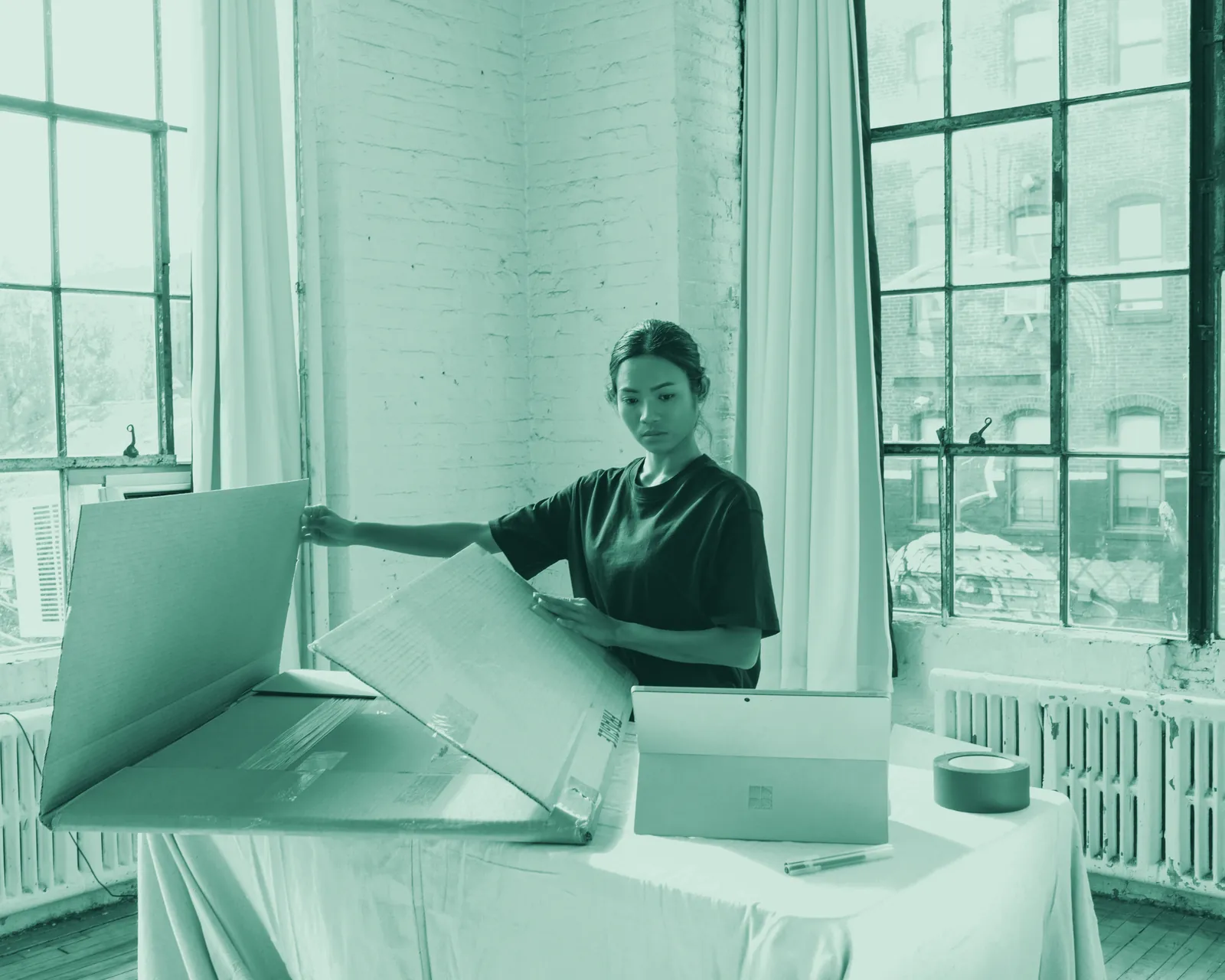 Illustrative photo: a woman packing an order into a cardboard box at a table.