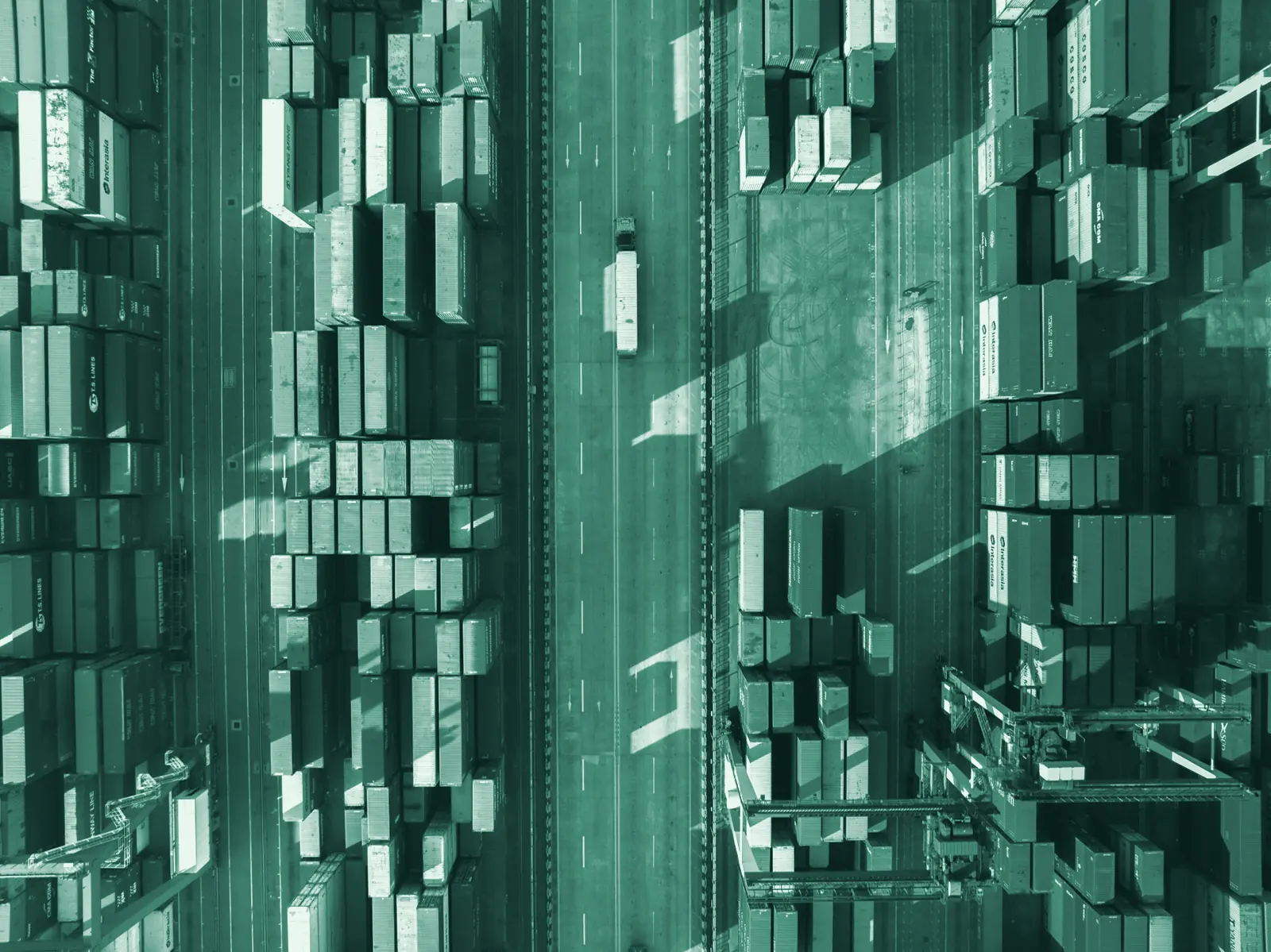 Illustrative photo: stacked shipping containers at a port, seen from above.