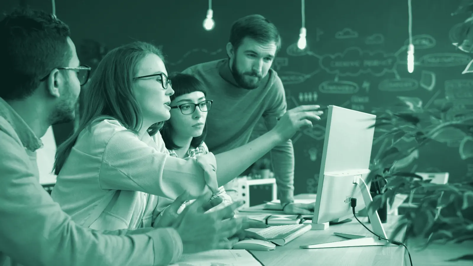 Illustrative photo: a team gathered around a screen, planning work together.